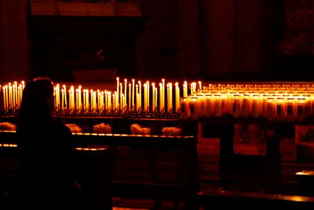 woman_with_prayer_candles_credit_massimo_valiani_via_flickr_cc_by_nc_20_cna_6_29_15